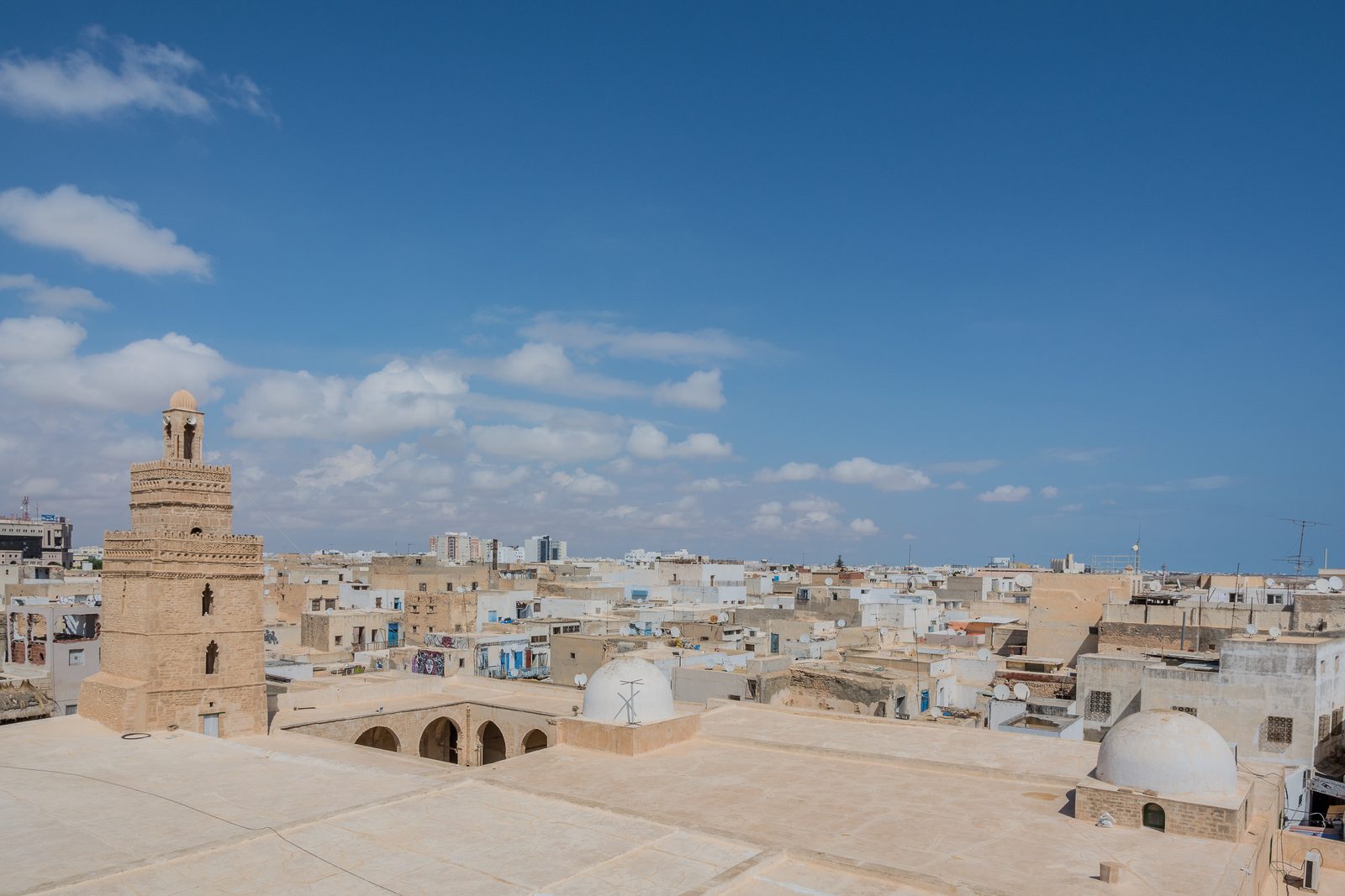Vue des toits de la médina de Sfax avec le minaret de la Grande Mosquée, illustrant le patrimoine bâti de la ville